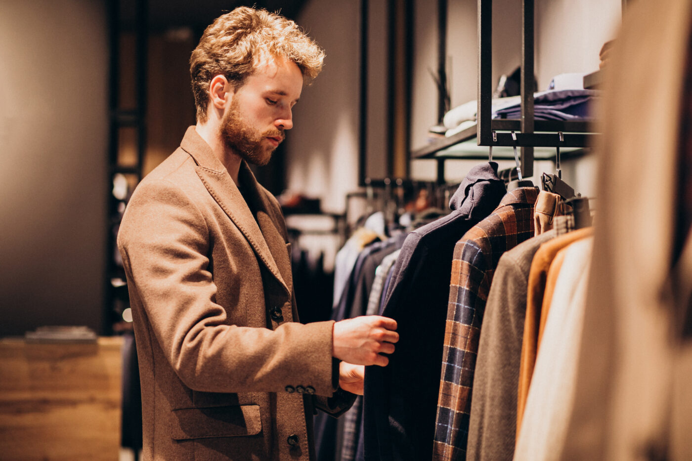 young handsome man choosing clothes shop